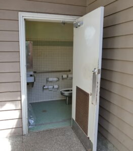 A picture of the inside of the wheelchair accessible bathroom in the Visitor Center Courtyard. It shows the area around the toilet and grab bars.